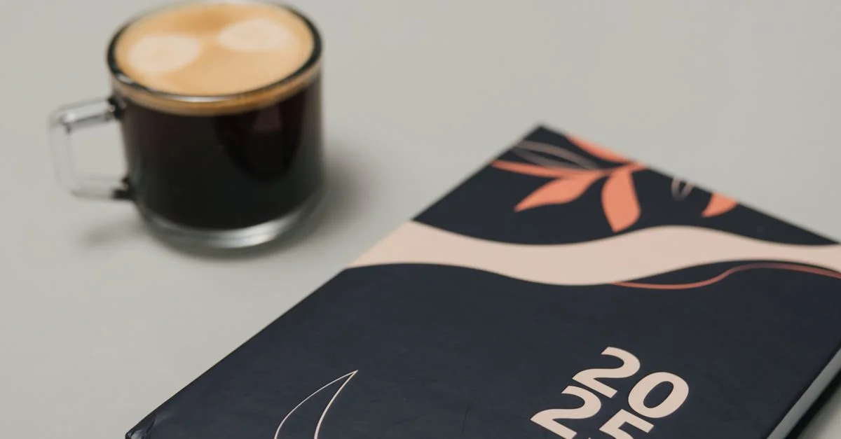 Agenda 2025 élégant avec une tasse à café sur un bureau neutre, parfait pour les séances de planification.